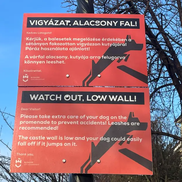 Táblák figyelmeztetnek az alacsony várfalra a Budai Várban